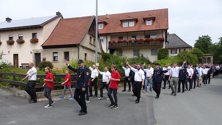 n der Spitze der 90 Wehren, Vereine und Gruppen beim Kreisfeuerwehrtag des Landkreises Kulmbach schritten gemeinsam die Feuerwehr und der Burschenverein Gössenreuth. Klaus-Peter Wulf