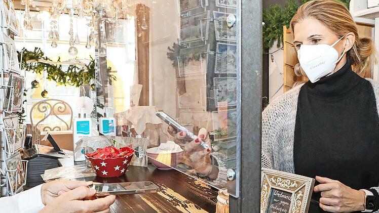 Corina Lösch von „Moyo home & garden“ in Forchheim kontrolliert den Impfausweis einer Kundin.