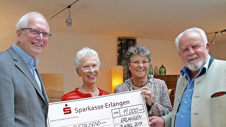 Angela und Hartmut Dörfler (links) übergeben den Scheck an Reinhard Erös (rechts).  Foto: IH