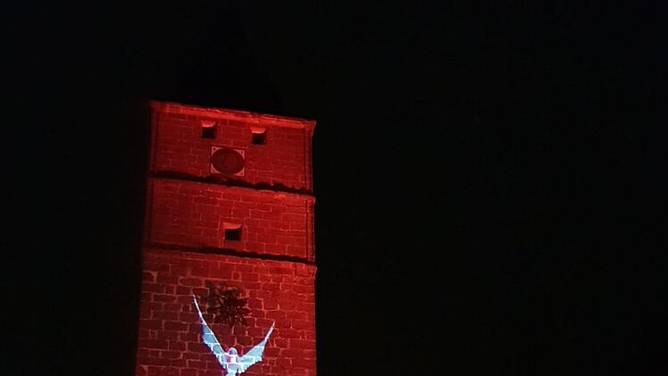 Eine weiße Taube flatterte an der roten Fassade des Grauturms