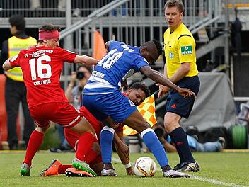 Großer Kampf und manchmal auch ein bisschen Krampf: Die Würzburger Peter Kurzweg (links) und Royal-Dominique Fennell streiten sich mit dem Duisburger Kingsley Onuegbu ums Spielgerät. Foto: Foto2press, Frank Scheuring