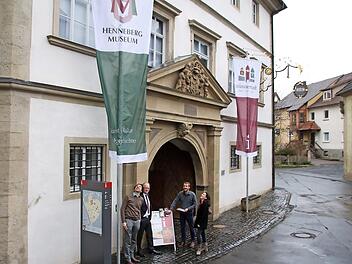 Nikolas Zenzen, Helmut Blank, Kilian Düring, und Christine Schikora haben die neuen Fahnen am Schloss gehisst. Die linke trägt das Wappen des Hennebergmuseums, die rechte das neue Marketing-Logo und das "i" für Touristinformation.  Foto: Thomas Malz