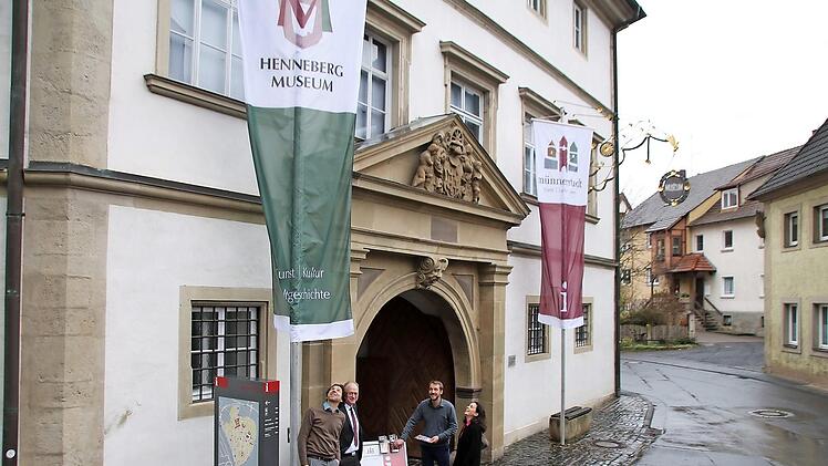 Nikolas Zenzen, Helmut Blank, Kilian Düring, und Christine Schikora haben die neuen Fahnen am Schloss gehisst. Die linke trägt das Wappen des Hennebergmuseums, die rechte das neue Marketing-Logo und das "i" für Touristinformation.  Foto: Thomas Malz