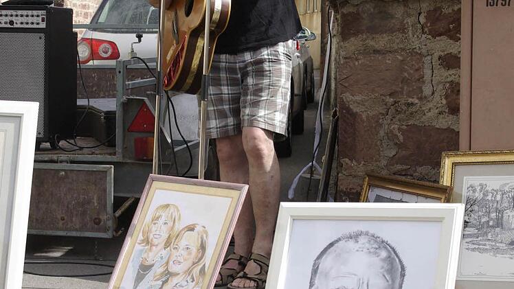 Der Hammelburger Konny Albert präsentiert sich mit Mundartsongs aber auch mit Portraits, zum Beispiel von Bürgermeister Kickuth (im Vordergrund).  Foto: Winfried Ehling