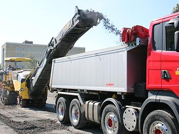 Am Montag trug die Fräsmaschine in der Georg-Hagen-Straße die obere Fahrbahnschicht ab und schleuderte sie auf einen Lkw. Am Mittwoch soll dort dann neu asphaltiert werden.  Fotos: Andreas Schmitt
