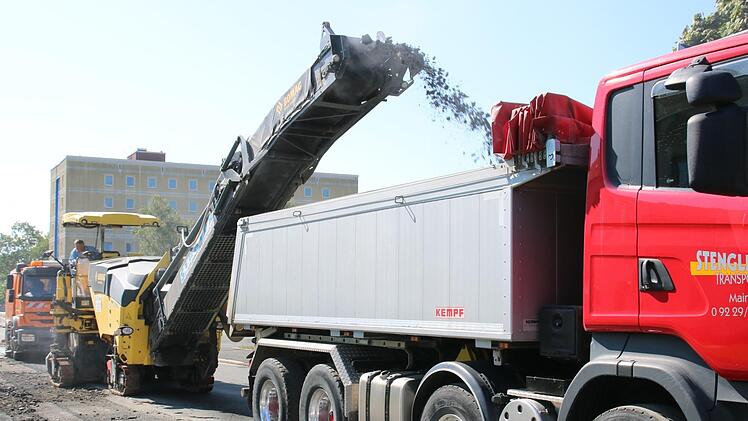 Am Montag trug die Fräsmaschine in der Georg-Hagen-Straße die obere Fahrbahnschicht ab und schleuderte sie auf einen Lkw. Am Mittwoch soll dort dann neu asphaltiert werden.  Fotos: Andreas Schmitt