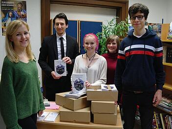 Sarah Hofmeister (links), Christin Martin (Dritter von rechts), Lea Raab und Jonathan Jehn (rechts) überreichten die frisch gedruckte Broschüre "Jüdisches Leben in Brückenau" an Bibliothekar Jan Marberg (Zweiter von links). Foto: Stephanie Elm