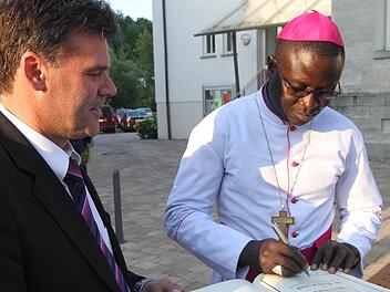 Andre Gueye war natürlich in zehn Jahren schon öfters in Kirchaich als Urlaubspriester. Jetzt als Bischof schrieb er sich gerne in das Goldene Buch der Gemeinde Oberaurach ein. Fotos: Günther Geiling