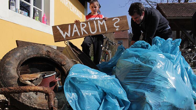 Die Frage nach dem "Warum" bleibt. Die freiwilligen Müllsammler haben ein Schild gefertigt, das schon am Ortsrand von Ailsbach auf die sinnlose Verschmutzung der Landschaft aufmerksam machen soll.  Yannick Hupfer