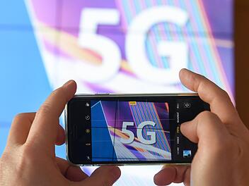 Ein Journalist fotografiert vor dem Start der Auktion von 5G-Mobilfunkfrequenzbl&ouml;cken am Mainzer Technik-Standort der Bundesnetzagentur das K&uuml;rzel &laquo;5G&raquo; mit seinem Smartphone.  W&auml;hrend in Deutschland die Frequenzen versteigert werden, haben die St&auml;dte Br&uuml;ssel und Genf den Aufbau des Hochgeschwindigkeitsnetzes gestoppt.Foto: Arne Dedert/dpa