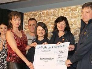 Stephanie Karrasch übergibt einen 1000-Euro-Scheck an Karl-Heinz Welker (r.), Carolin Rayczyk (3. v. r.) und Lucia Taschner (2. v. r.) vom Wünschewagen-Team. Foto: Mathias Erlwein