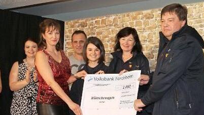 Stephanie Karrasch übergibt einen 1000-Euro-Scheck an Karl-Heinz Welker (r.), Carolin Rayczyk (3. v. r.) und Lucia Taschner (2. v. r.) vom Wünschewagen-Team. Foto: Mathias Erlwein