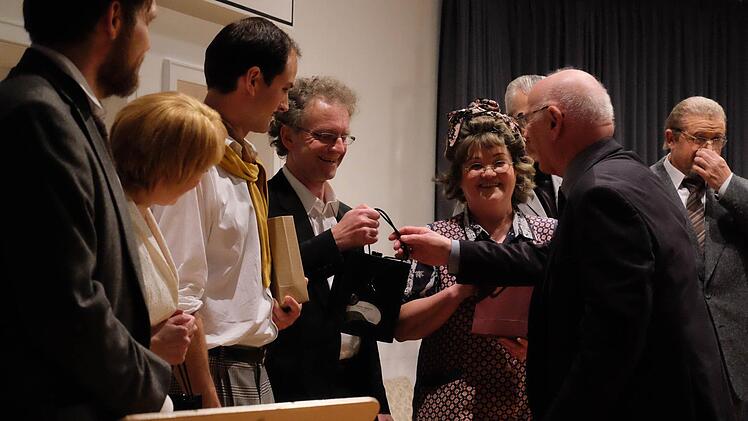 Theaterring-Leiter Heribert Schilling (rechts) überreicht ein kleines Dankeschön an das Ensemble.