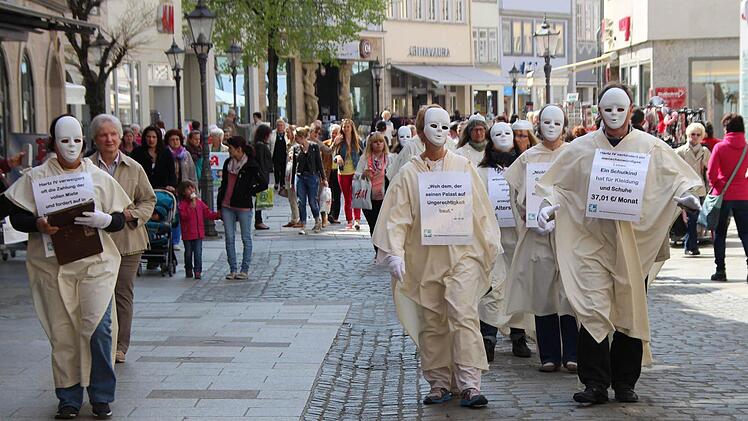 Mit ihrem Zug durch die Spitalgasse machen Mitarbeiterinnen und Mitarbeiter der katholischen Arbeitslosenberatungsstellen auf die Konsequenzen von Hartz IV für Betroffene aufmerksam. Foto: Helke Renner