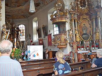 Sibylle Horn (am Ambo) und Annette Urban (rechts vorne sitzend) führten in beeindruckender Weise in der Wallfahrtskirche "Mariä Geburt" Glosberg in Leiden- und Lebensgeschichten von Märtyrern ein.  Foto: K. Hofmann