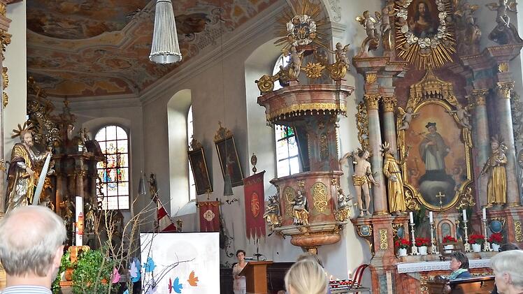 Sibylle Horn (am Ambo) und Annette Urban (rechts vorne sitzend) führten in beeindruckender Weise in der Wallfahrtskirche "Mariä Geburt" Glosberg in Leiden- und Lebensgeschichten von Märtyrern ein.  Foto: K. Hofmann