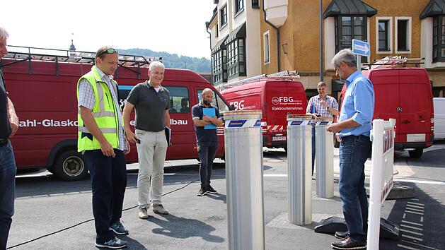 Peter Drozynski (rechts) f&auml;hrt die drei Poller, die am neuen Kreisel in der Webergasse stehen, per Fernbedienung hoch. Fotos: Alexander Hartmann