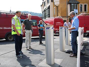 Peter Drozynski (rechts) fährt die drei Poller, die am neuen Kreisel in der Webergasse stehen, per Fernbedienung hoch. Fotos: Alexander Hartmann