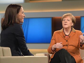 Bundeskanzlerin Angela Merkel (r, CDU) und die Moderatorin Anne Will unterhalten sich am 28.02.2016 in Berlin vor Beginn einer Sendung mit dem Thema "Debatte über Flüchtlingspolitik in Deutschland". Foto: Rainer Jensen/dpa