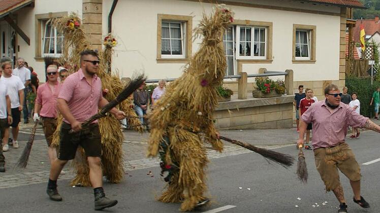 Kaum von der Kapelle zum Dorfplatz geleitet, gingen die Strohbären auch schon auf die Suche nach jungen Damen, die sie zu Boden reißen konnten.  Fotos: Sabine Weinbeer