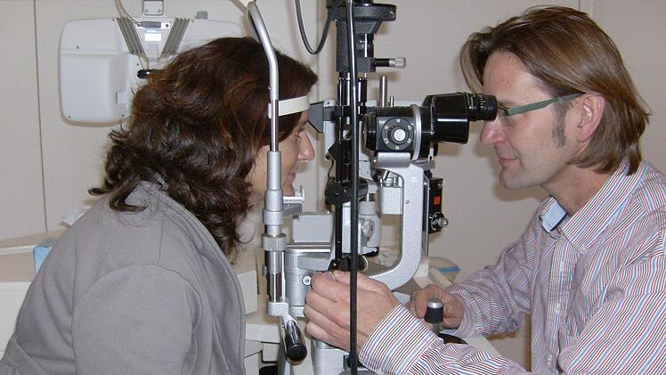 Augenarzt Klaus Königsreuther (r.) untersucht eine Patientin in seiner Eckentaler Praxis. Foto: Malbrich