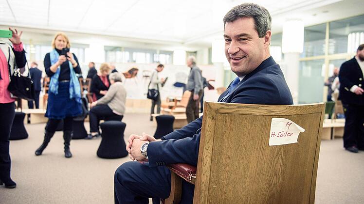 Der bayerische Finanzminister Markus Söder (CSU) sitzt in Nürnberg auf der Ausstellung «Sitzpunkte - Was ist ein guter Stuhl?» auf seinem alten Sessel aus dem bayerischen Landtag. Die Ausstellung kann vom 2. bis 19. Februar 2016 im Heimatministerium in Nürnberg besichtigt werden. Foto: Nicolas Armer/dpa