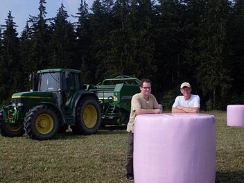Sie sind stolz, dass sie mit ihrer Aktion helfen können. Bernd Löffler (links) und sein Bruder Dieter mit ihrer pinken Ballensilage. Foto: Susanne Deuerling