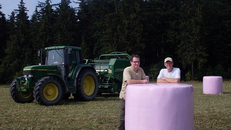 Sie sind stolz, dass sie mit ihrer Aktion helfen können. Bernd Löffler (links) und sein Bruder Dieter mit ihrer pinken Ballensilage. Foto: Susanne Deuerling