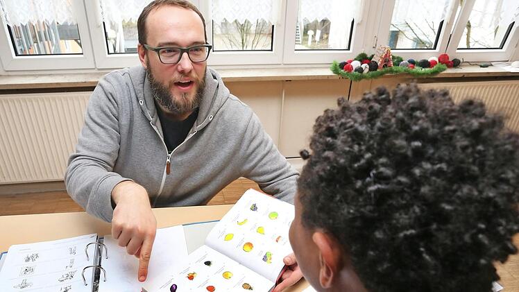 Ein 14-jähriger unbegleiteter Flüchtling aus Eritrea wird bei seinen Deutsch-Hausaufgaben von einem Erzieher betreut.  Foto: Karl-Josef Hildenbrand, dpa