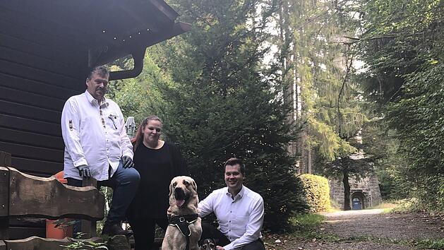 Neu auf der Arnoldhütte: Die Wirtsleute Hans-Jürgen und Michaela Ühlin mit Geschäftsführer Torsten Klein sowie den Hunden Ocean, ein vierjähriger Dogge-Labrador-Mischling, und Jamie-Oliver - ein neunjähriger Jack-Russell-Terrier. Hinten der Prinzregententurm, der im geplanten Märchenwald zum "Rapunzel-Turm" werden soll. Fotos: Christoph Böger