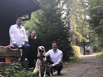 Neu auf der Arnoldhütte: Die Wirtsleute Hans-Jürgen und Michaela Ühlin mit Geschäftsführer Torsten Klein sowie den Hunden Ocean, ein vierjähriger Dogge-Labrador-Mischling, und Jamie-Oliver - ein neunjähriger Jack-Russell-Terrier. Hinten der Prinzregententurm, der im geplanten Märchenwald zum "Rapunzel-Turm" werden soll. Fotos: Christoph Böger