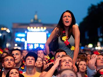 Fußballfans schauen sich im Juni 2012 auf der Fanmeile am Brandenburger Tor in Berlin das EM-Halbfinale Deutschland gegen Italien an. Foto: Boris Roessler/dpa