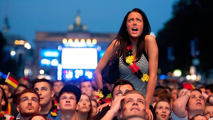 Fußballfans schauen sich im Juni 2012 auf der Fanmeile am Brandenburger Tor in Berlin das EM-Halbfinale Deutschland gegen Italien an. Foto: Boris Roessler/dpa