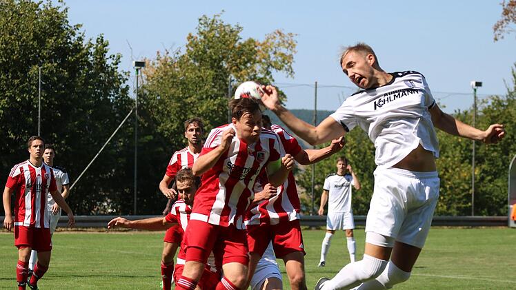 Angeschoben von mehreren Teamkollegen geht Fuchsstadts Kapitän Simon Bolz ins Kopfballduell mit diesem Karlburger.Sebastian Schmitt
