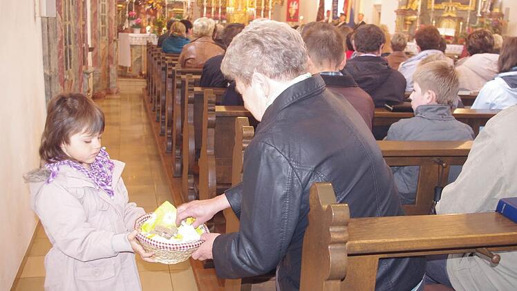Die kleine Hanna teilt in der Kirche das Brot mit den Gläubigen.