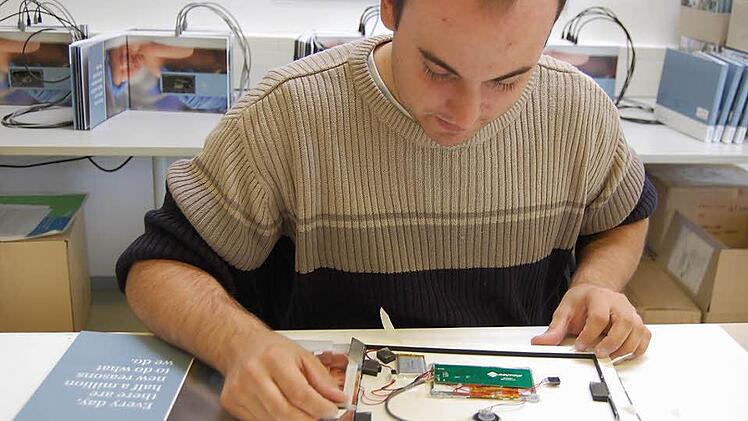 Wenn die technischen Module fertig sind, baut André Gieselbrecht die kleinen Bildschirme in die Broschüren ein. Fotos: Christina Hauptmann