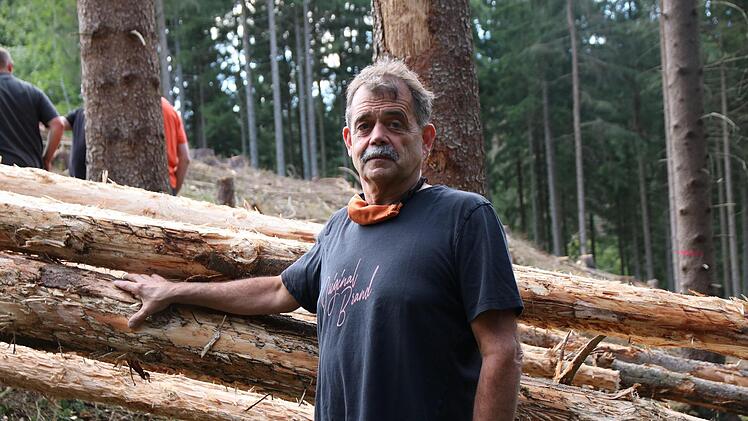 Waldbesitzer Gerald Schneider steht vor seinen Käferbäumen, die der Harvester gefällt hat. Foto: Christian Schuberth