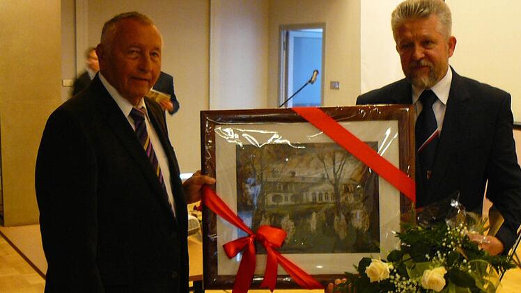Mogilanys Bürgermeister Krzystof Musial (rechts) überreicht seinem Kollegen Heinz Burges aus Untersteinach (links) als Gastgeschenk ein Bild des Guthauses.