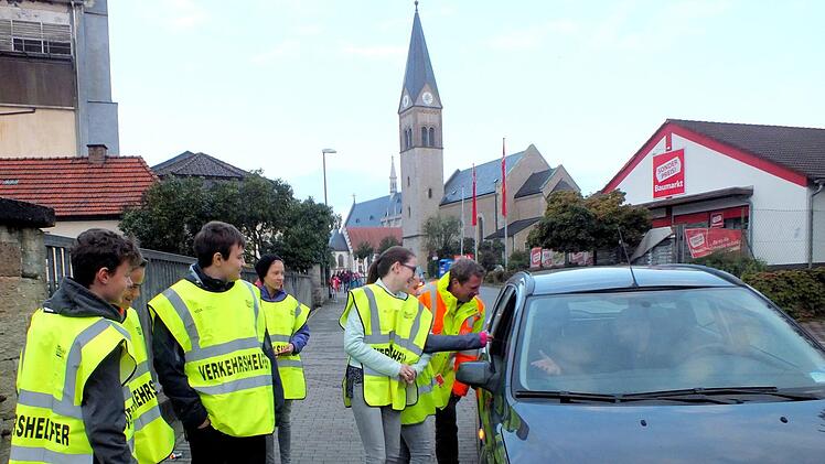 Bei der Aktion  "Denk an uns, fahr langsam" überreichten Schülerlotsen der Waldorfschule Haßfurt im Beisein von Polizeibeamten Autofahrern, die die 30-Kilometer-Geschwindigkeitsbegrenzung in der Straße "Am Ziegelbrunnen" in Haßfurt überschritten, die rote Karte. Und ein  lachendes Smiley als Belohnung erhielten Autofahrer für die Einhaltung des Tempolimitis.  ab