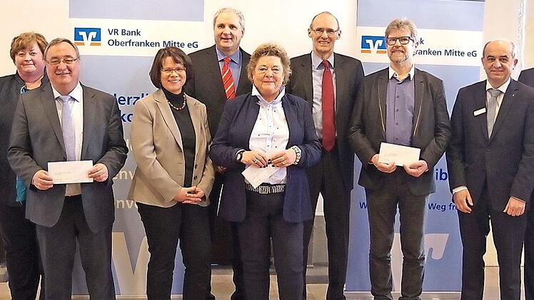 Die VR Bank Oberfranken Mitte spendet 12 000 Euro. Das Bild zeigt (v. l.) Renate Leive, Andrea Paschold, Reinhard Horn, Christa Bänisch, Steffen Rost, Anita Dauer, Harald Weichert, Klaus Marr sowie Geschäftsstellenleiter Thomas Kolb und den Generalbevollmächtigten Hans Jürgen Möhrle. Foto: Heike Schülein