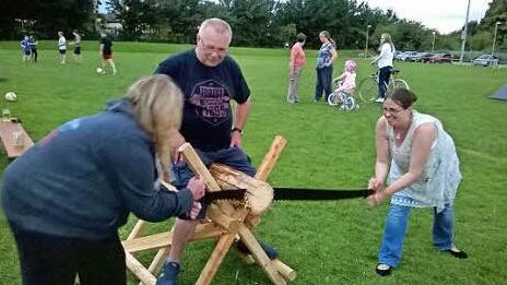 Ralf Leipold leitete den Holzsägewettbewerb in Bingham, bei dem auch die Twinning-Vorsitzende Claire mit Hand anlegte.  Fotos: Friedwald Schedel