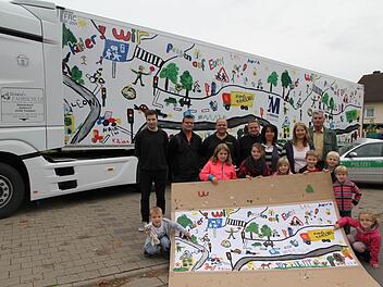 Die Kinder zeigen das Originalbild, das jetzt den Lkw-Auflieger ziert: "Kinder, wir passen auf Euch auf", so der Appell.  Foto: Erlwein