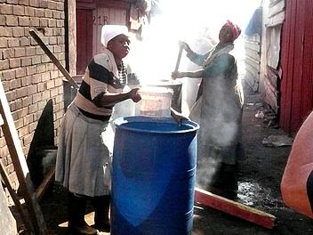 Zwei Frauen beim Bierbrauen im Township. Foto: Günther Geiling
