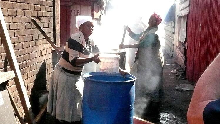 Zwei Frauen beim Bierbrauen im Township. Foto: Günther Geiling