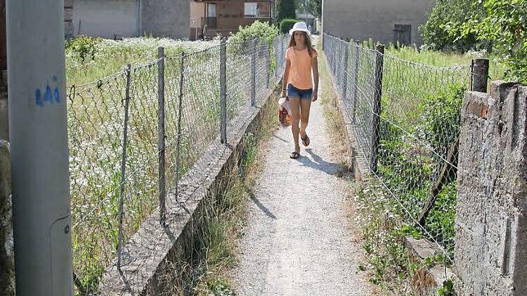 Ein Geflecht von öffentlich gewidmeten, geschotterten und teils romantisch beleuchteten Schleichwegen durchzieht in Pettstadt die Ortsmitte. Die offiziell "Etterwege" genannten Verbindungen zwischen Hauptstraße und Fabrikstraße sollen im Zuge der Nachverdichtung erhalten und aufgewertet werden.  Foto: Werner Baier