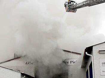 Feuerwehrmänner beim Löschen einer Halle mit Photovoltaik-Anlage.