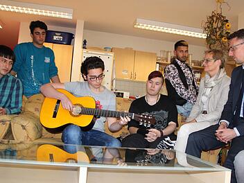 Der 17-jährige Mohammed aus Syrien zupft eine Melodie auf der Gitarre. Sabine Dittmar und Lars Castellucci lauschen den Klängen. Fast alle Jugendlichen auf dem Bild nutzten die Chance, sich mit den Politikern zu unterhalten. Foto: Ulrike Müller