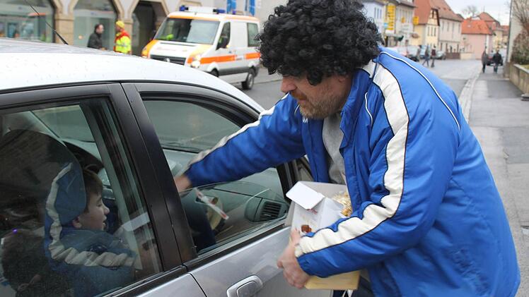 Vorstandsmitglied Olaf Wessel verteilt Kamelle auch an Autofahrer.Foto: Anette Schreiber