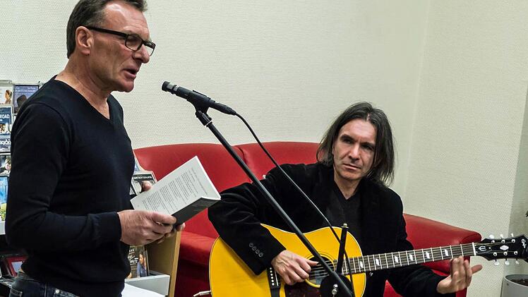 Manfred Kern und Harry Düll (Gitarre) gestalteten eine musikalische Lesung in der Stadtbücherei.Foto: Jochen Berger