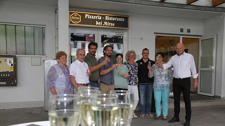 Mirsad Hazibegovic (4. v. l.) stößt mit Bürgermeister Claus Schwarzmann, dem Vorsitzenden des Sportvereins, Klaus Braun (3. v. l.),  und Mitgliedern des Gemeinderates auf ein gutes Gelingen des neuen Restaurants in der Bammersdorfer Ortsmitte an. Foto; Mathias Erlwein